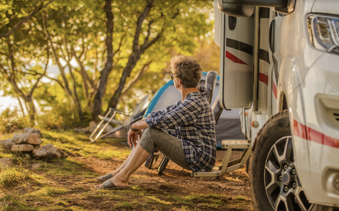 woman sitting on the ground outside of her outdoor RV